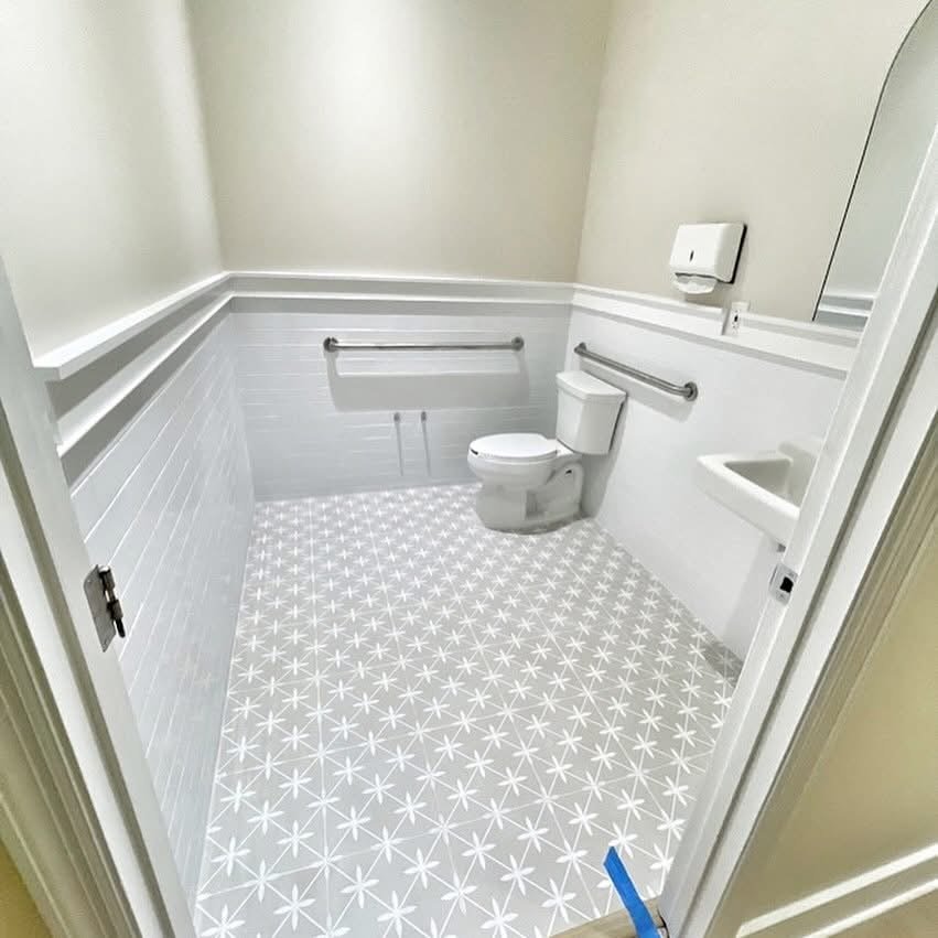 Accessible bathroom remodel with grab bars and tile flooring