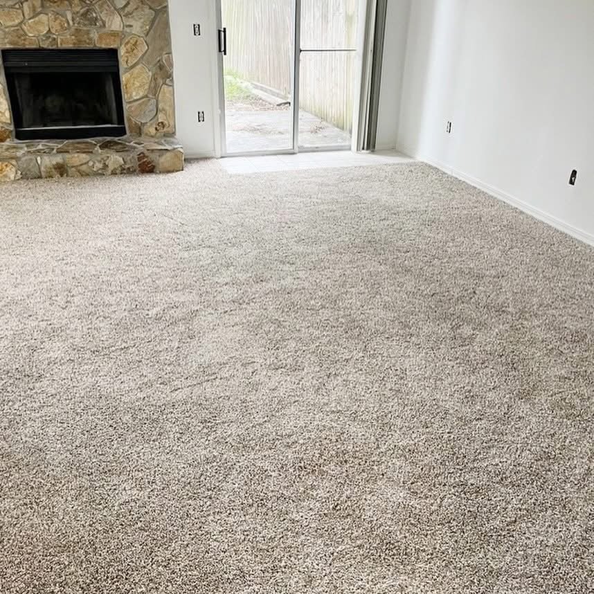 Living room with new carpet and stone fireplace surround