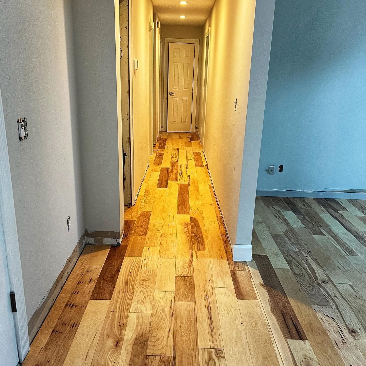 Hallway with light oak wood flooring and painted interior doors