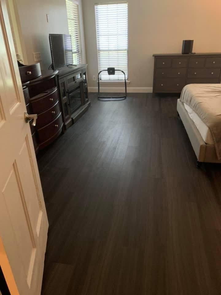 Bedroom with dark vinyl plank flooring installed in Fleming Island, FL