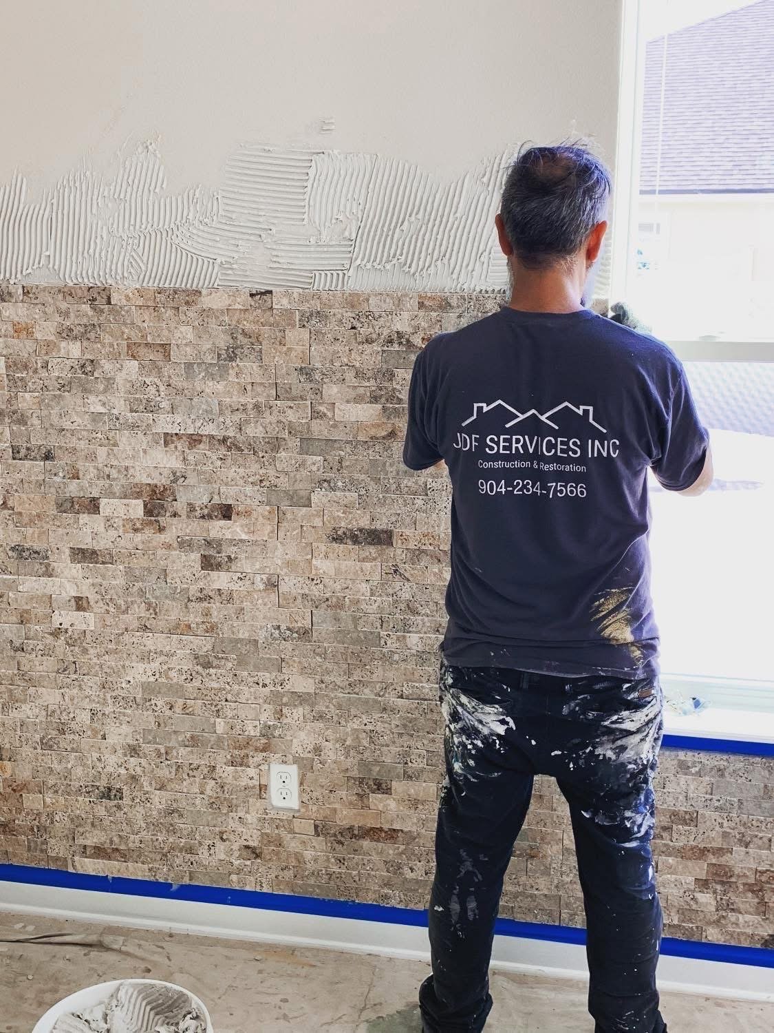 JDF Services technician applying stucco texture to an exterior wall