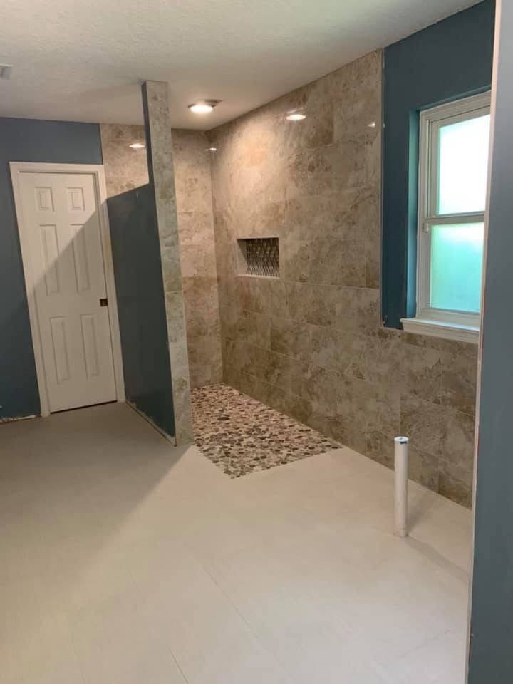 Remodeled bathroom shower with tile surround and pebble floor in Nocatee, FL
