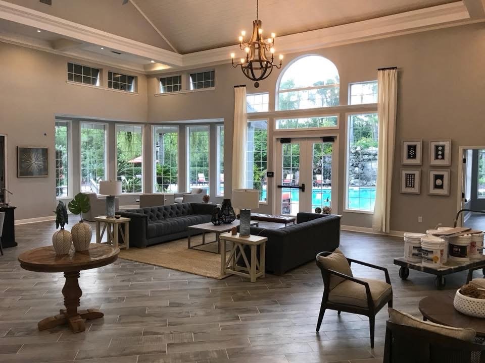 Open living room with vaulted ceiling, chandelier and arched windows after remodel