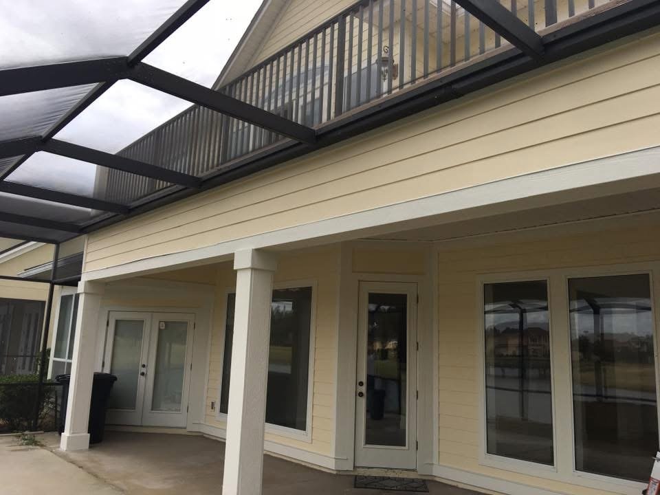 Exterior of a white home with covered porch and black screen enclosure in Jacksonville Beach, FL